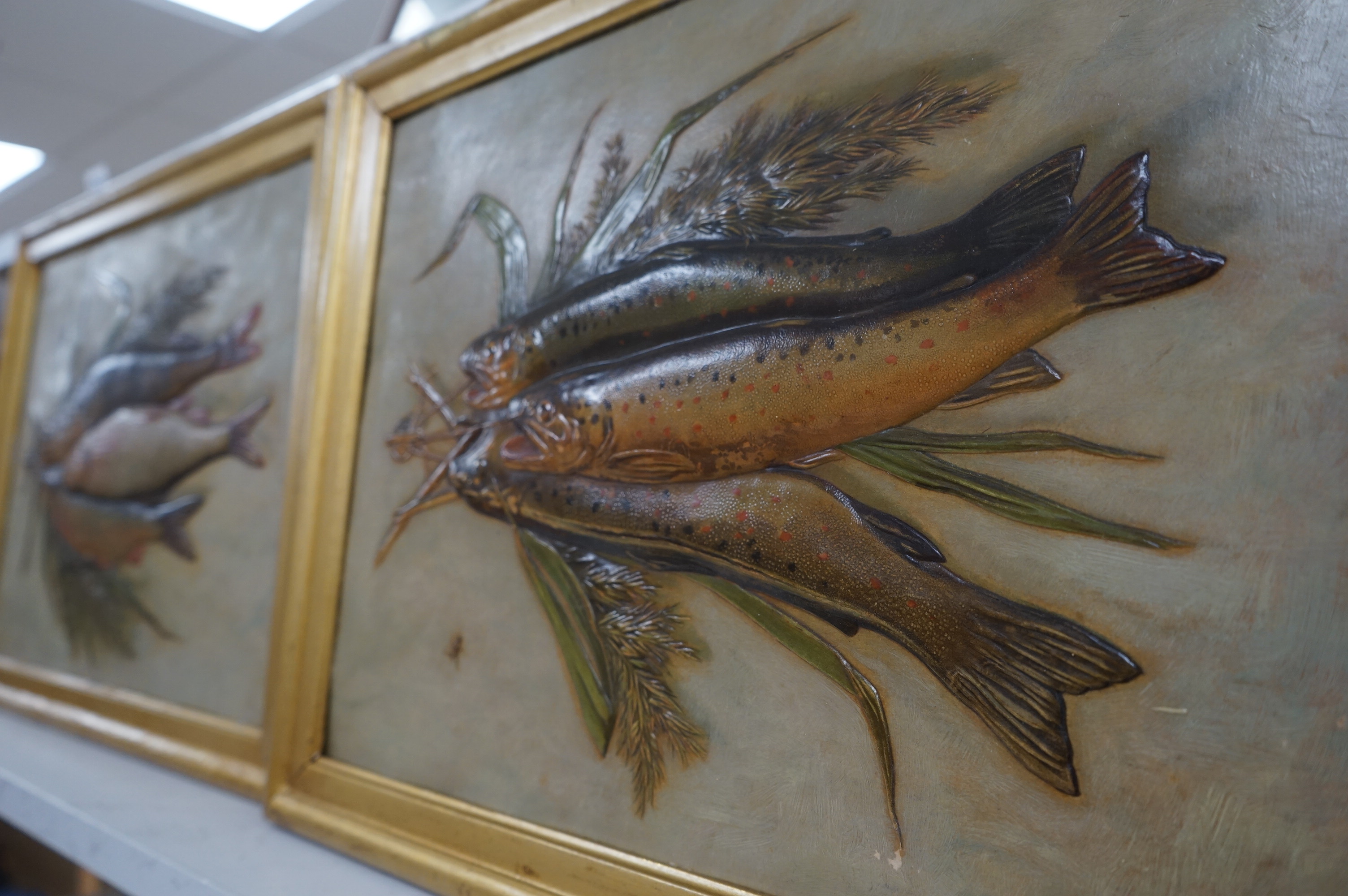 A pair of framed decorative relief 'fish' paintings. 39.5cm wide x 29cm high. Condition - some gilding worn on frames, minor scratches to paintings